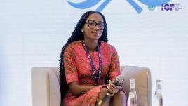 Jennifer sitting on a couch and holding microphone.