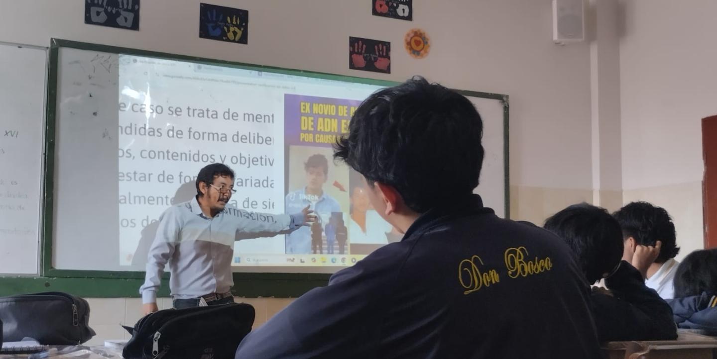 Gabriel standing in front of a white board as he talks to students.
