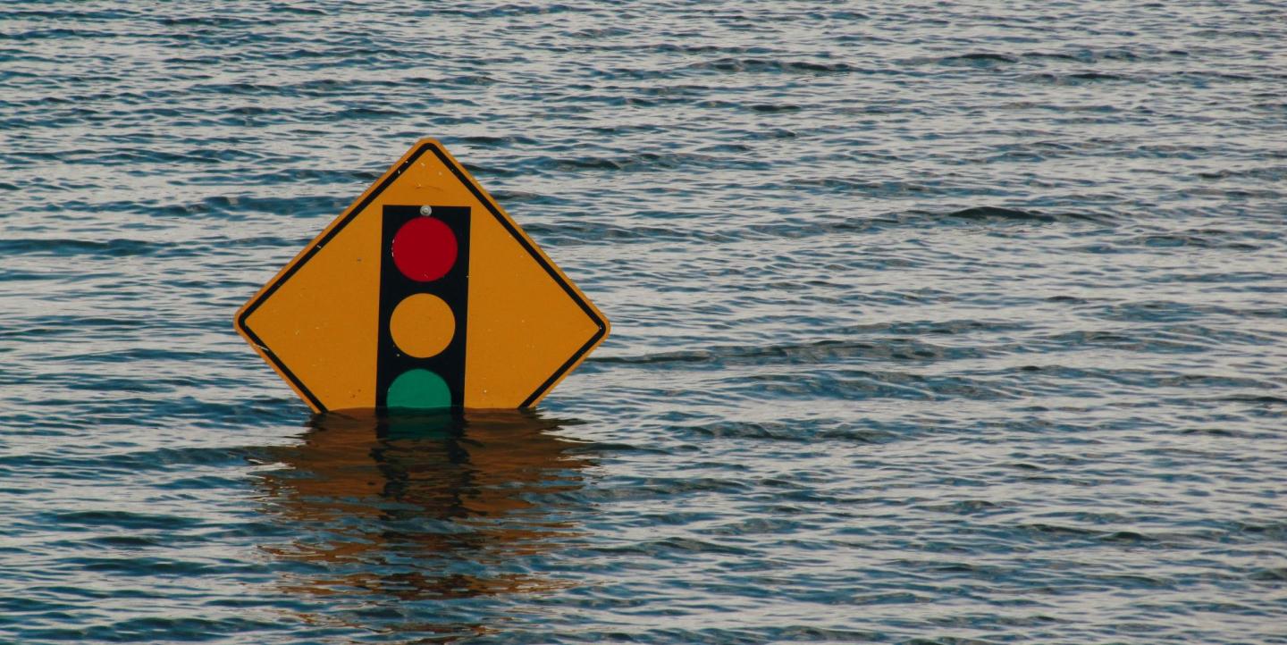 Traffic light sign half submerged in water during a flood