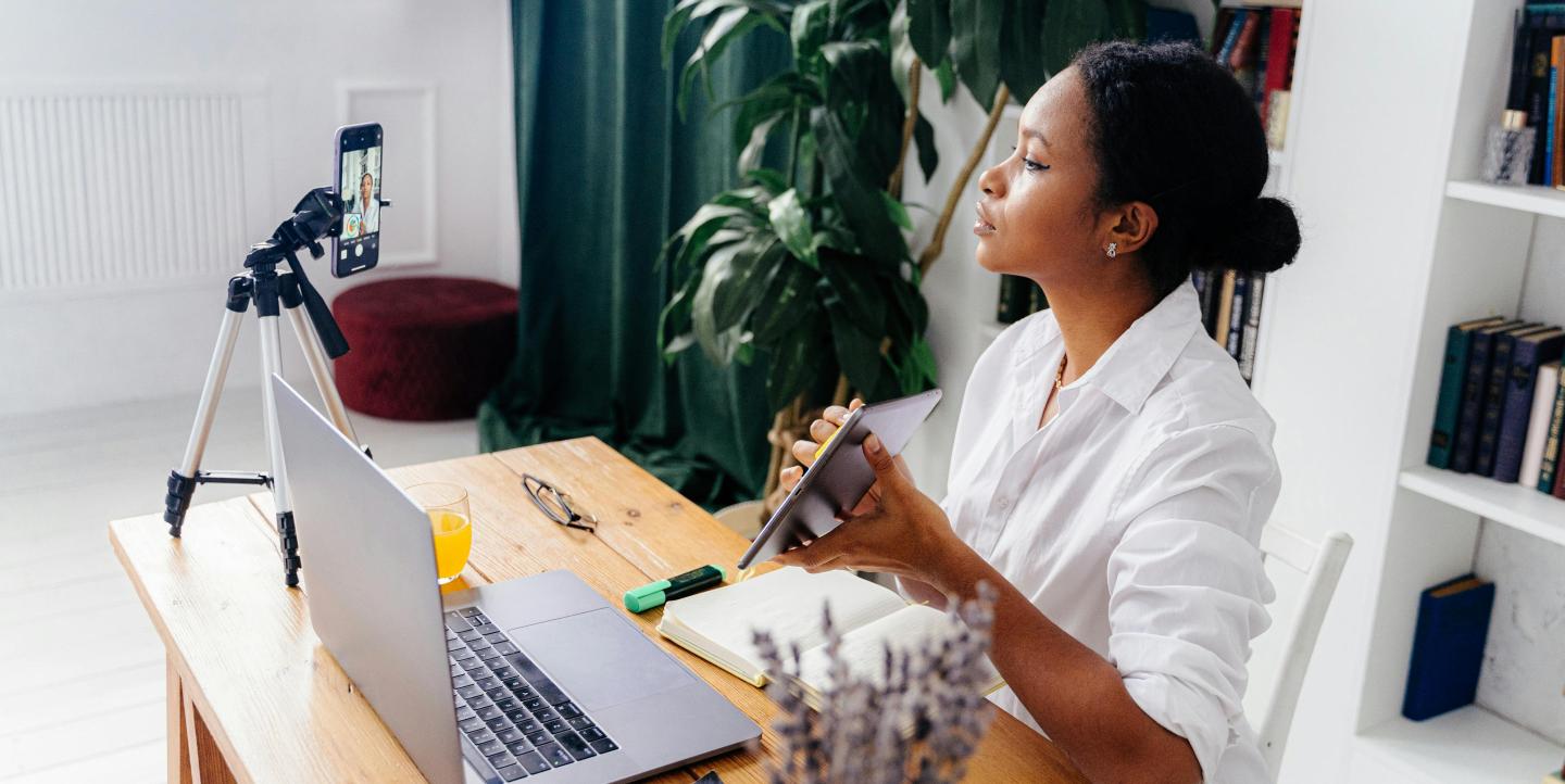 Une femme en plein tournage qui montre son iPad à la camera