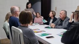 Talita standing at a table full of workshop attendees.