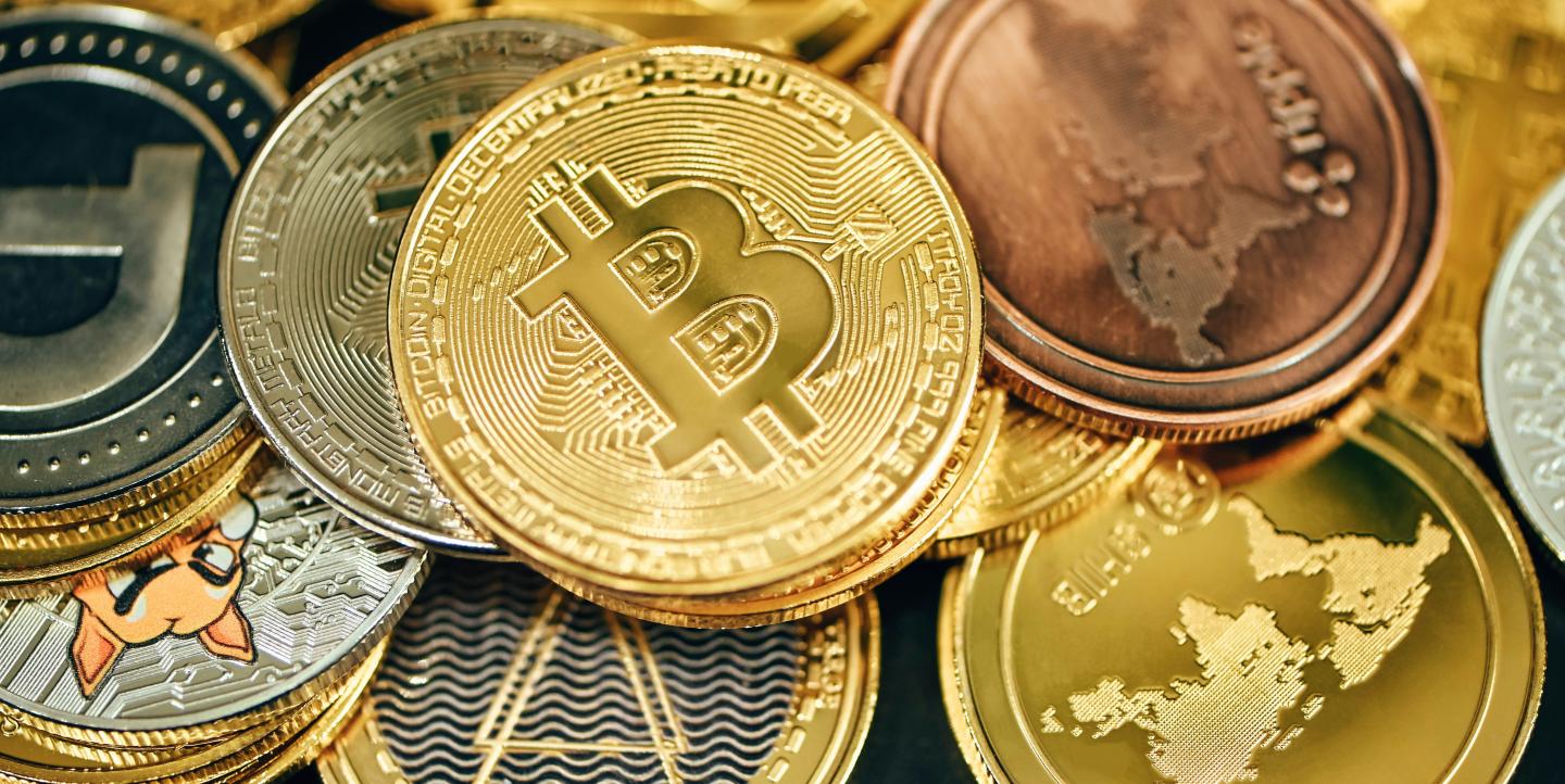 A pile of cryptocurrencies placed on a black background.