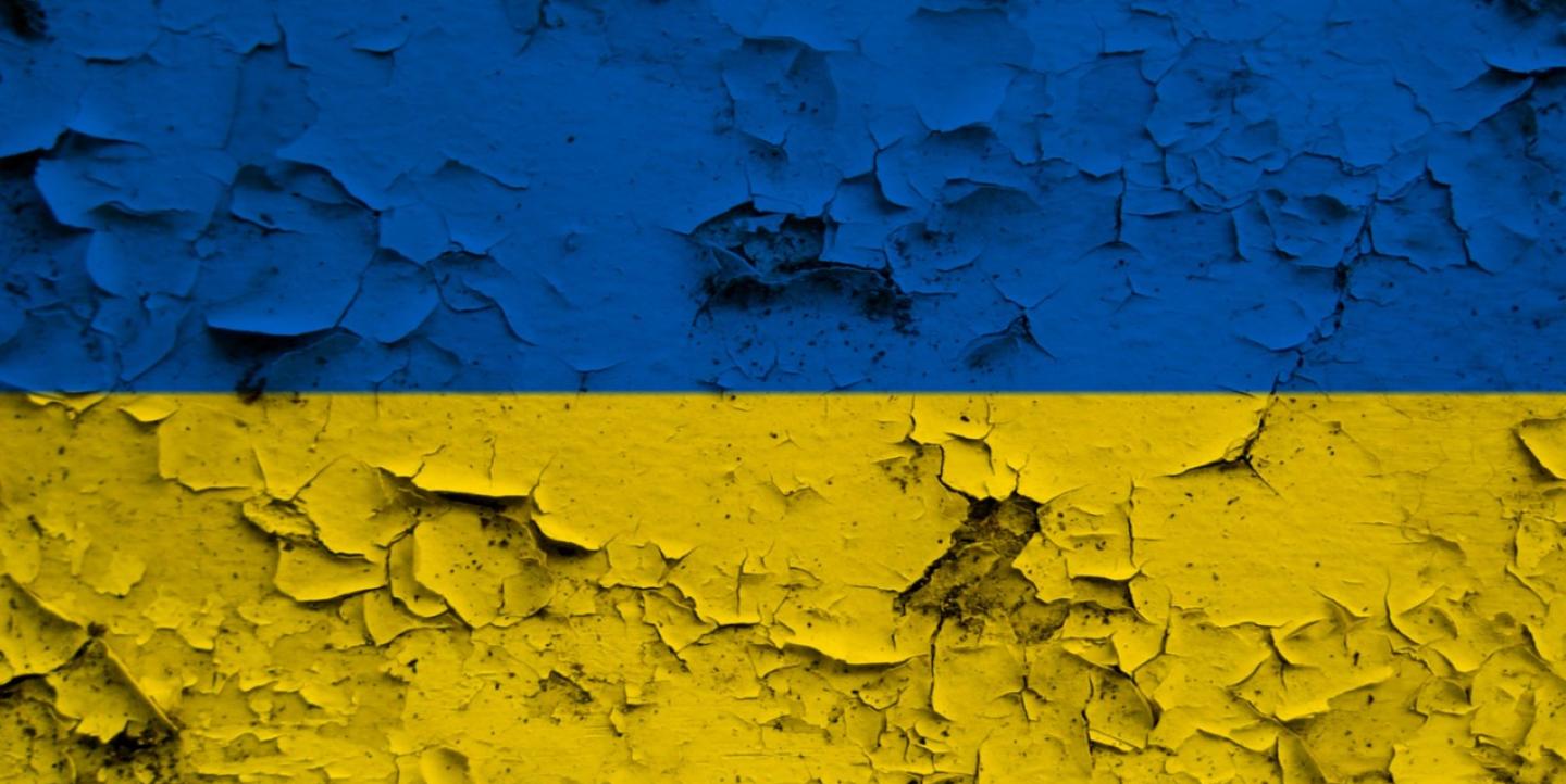 Blue and yellow flag with cracks in it.