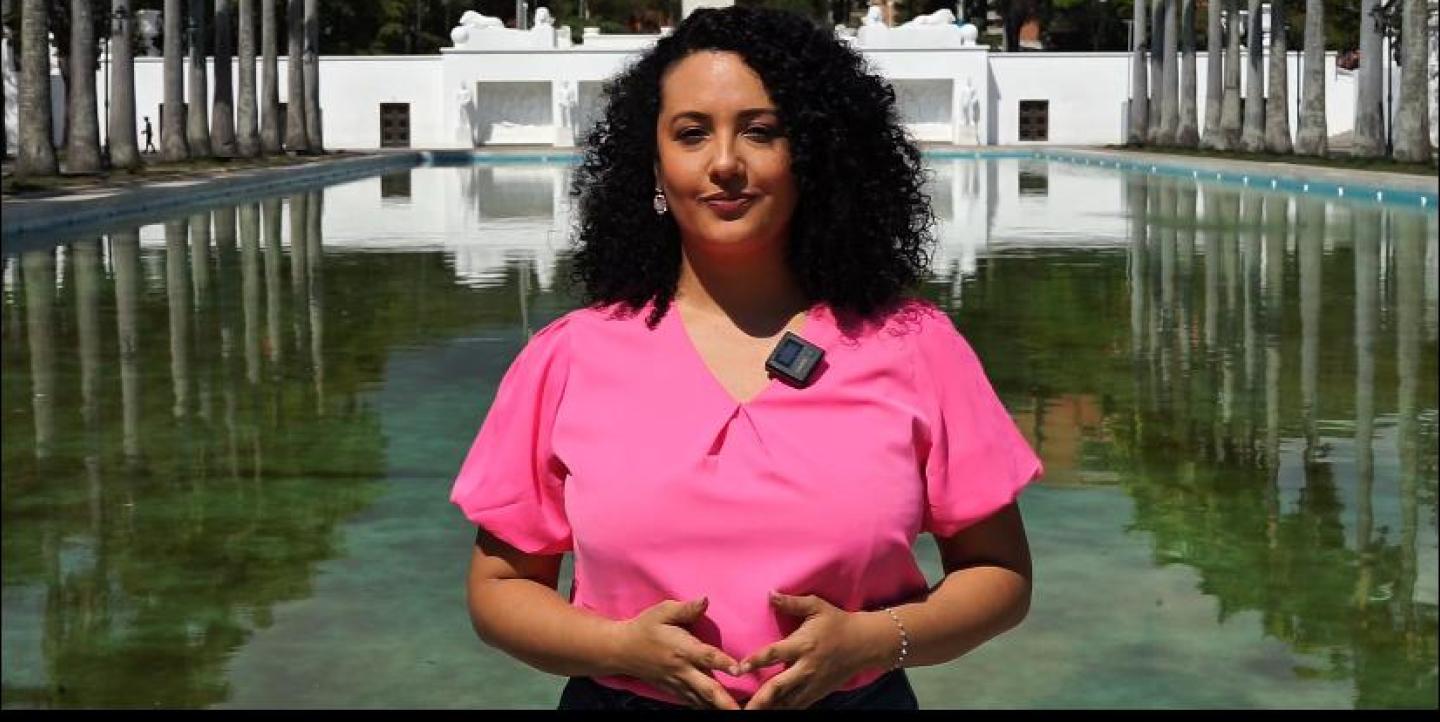 Ana devant la caméra portant un haut rose